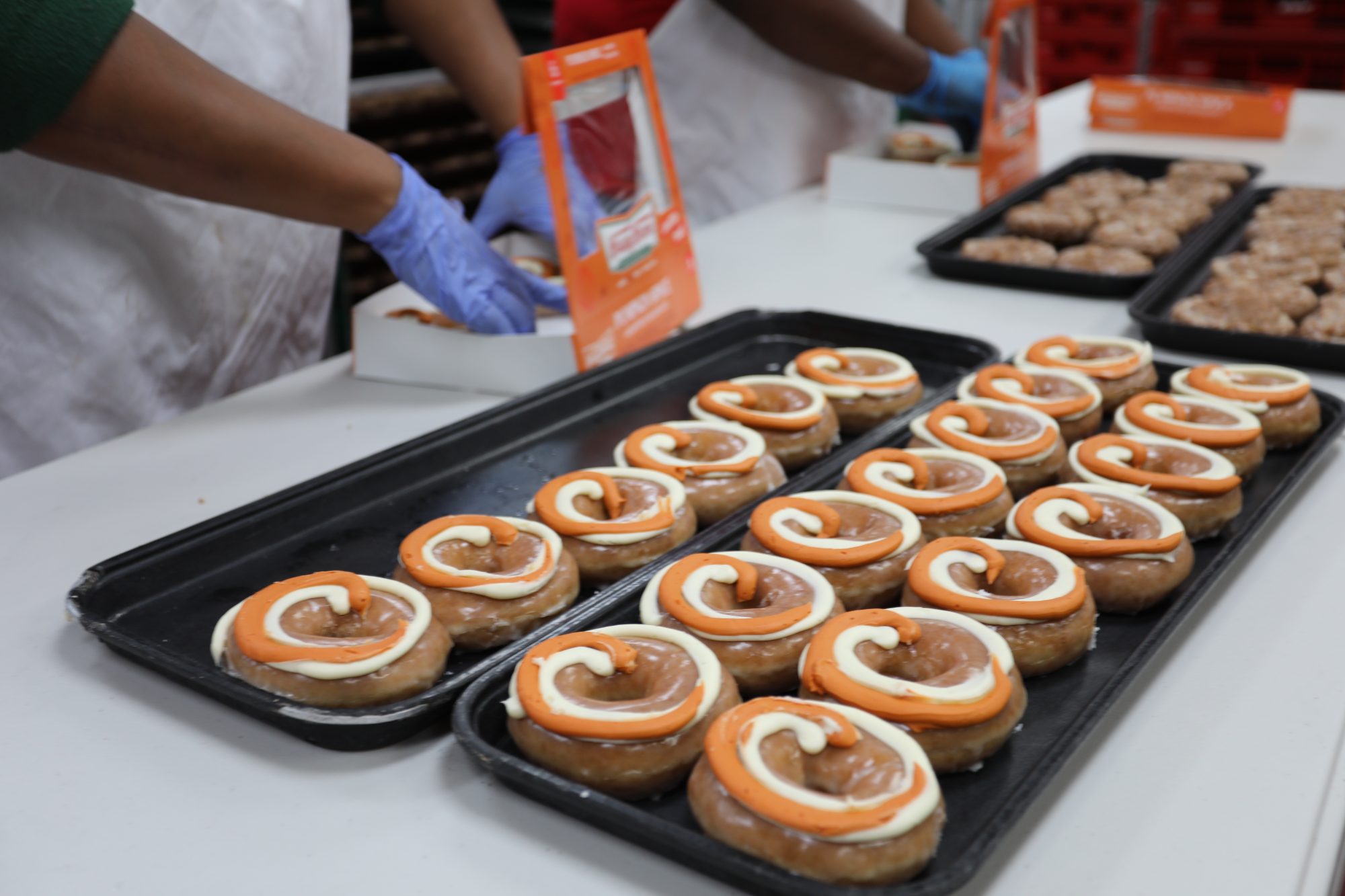 Krispy Kreme team members boxing doughnuts on the production line